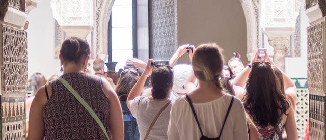 Female Carroll students taking pictures of a Spanish building