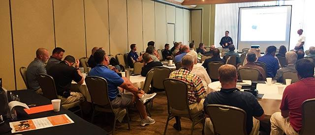 Attendees sit and are shown a powerpoint